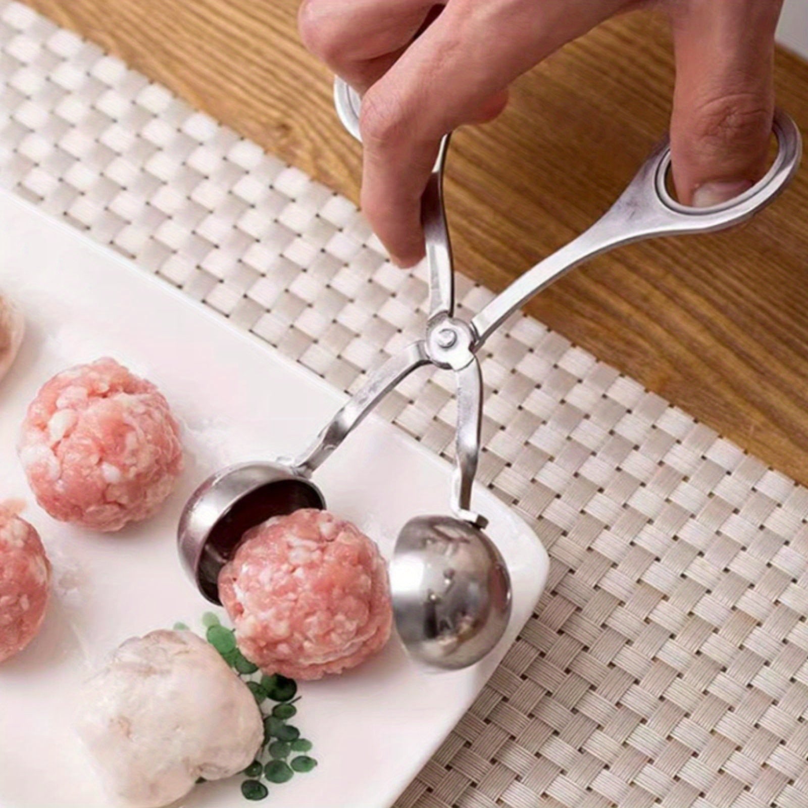 Stainless steel meatball press with non-slip handle.