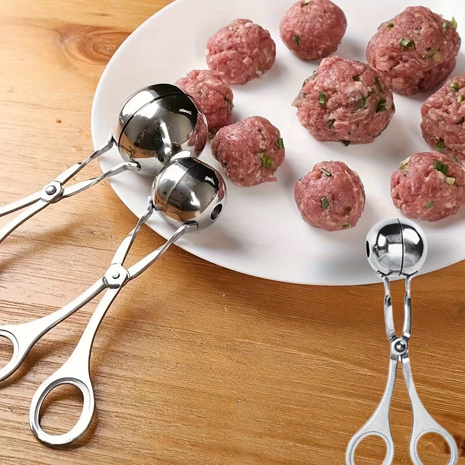 Stainless steel meatball press with non-slip handle.